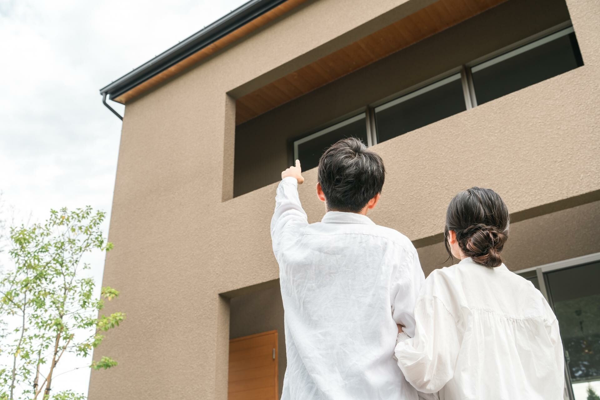 外壁を見ながら色や仕上がりを確認する家族